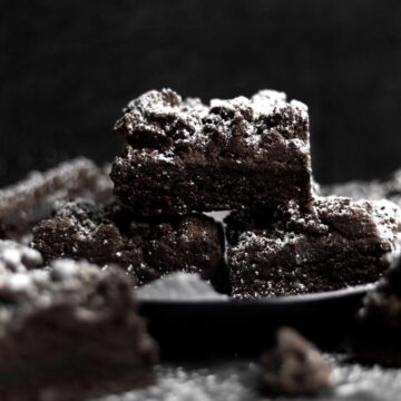 A square pyramid of Double Chocolate Crumb Cakes dusted heavily in powdered sugar.
