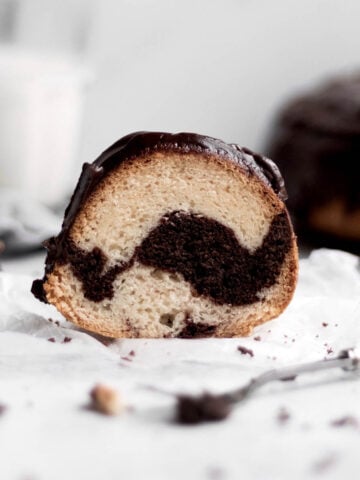 Gluten free Chocolate Glazed Marble Bundt Cake sits on parchment paper.