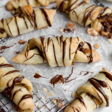 Golden-brown, gluten-free chocolate puff pastry twists with shiny melted chocolate.