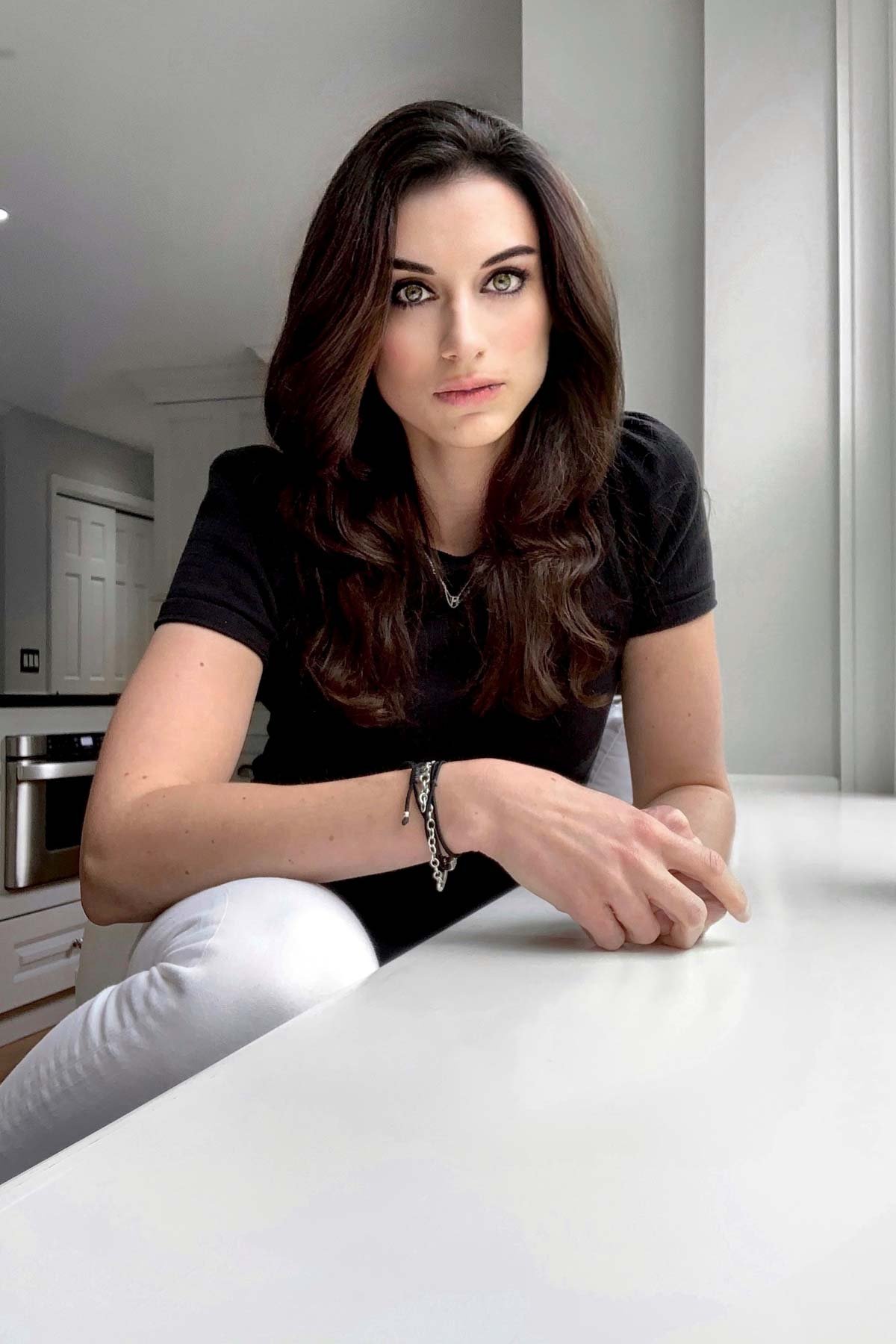 Lee sitting at a window in her kitchen.