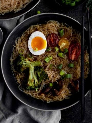 Gluten free Ramen with Roasted Tomatoes in a bowl with broccoli and an egg.