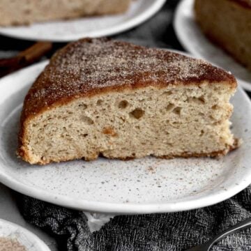 A delicious slice of light and fluffy, burnt sienna Cinnamon Tea Cake on a plate.