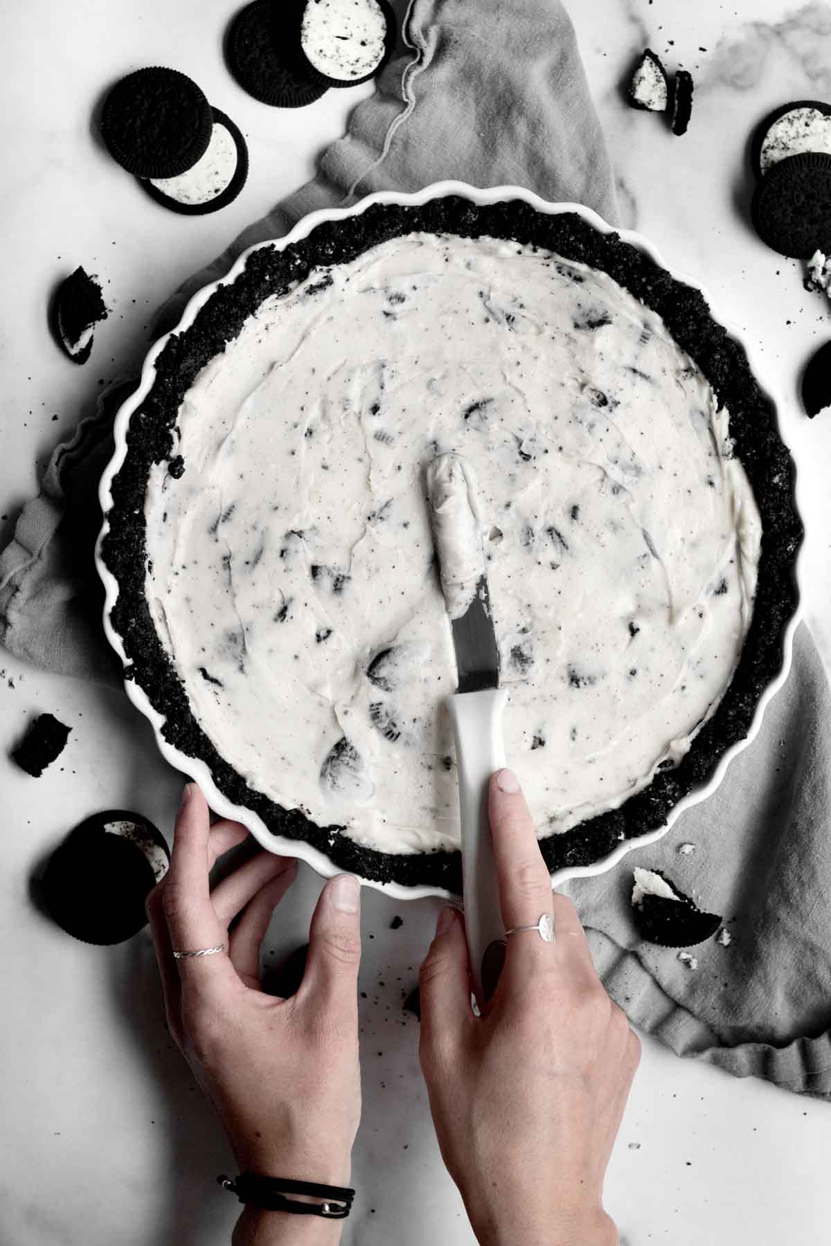 Smoothing out the Cookies and Cream filling on top of the crust.