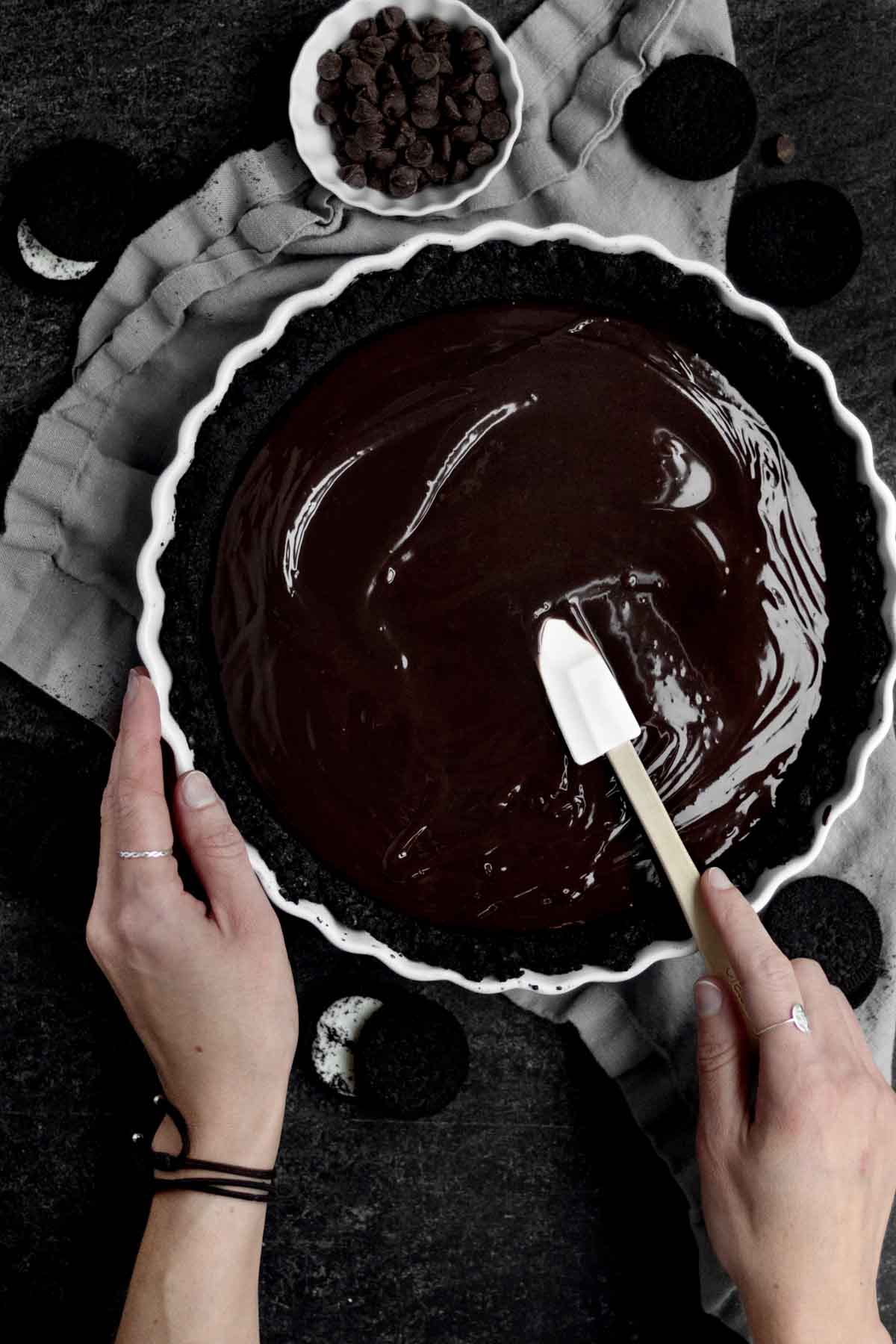Smoothing out the ganache on top of the sandwich cookie base.