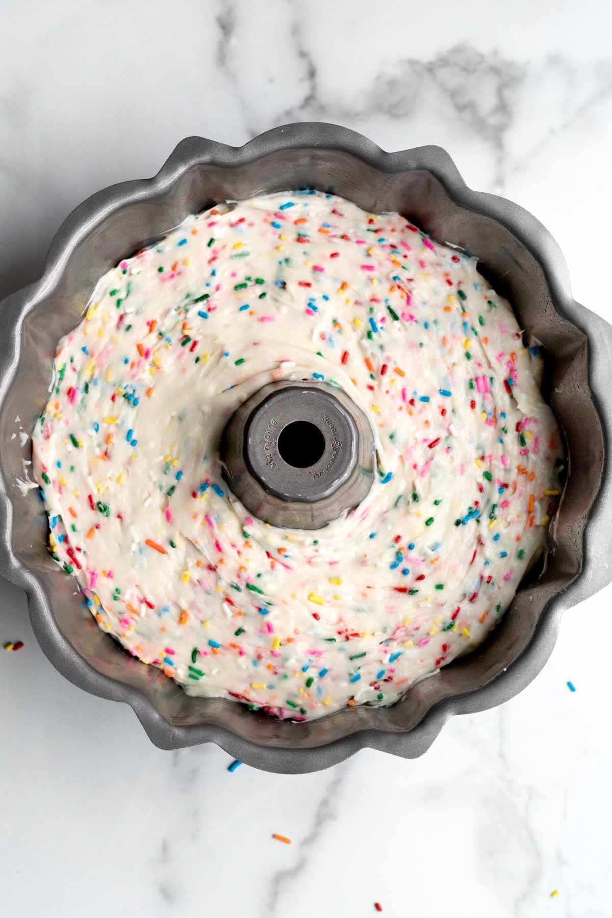 Filling up a round bundt pan with the batter.