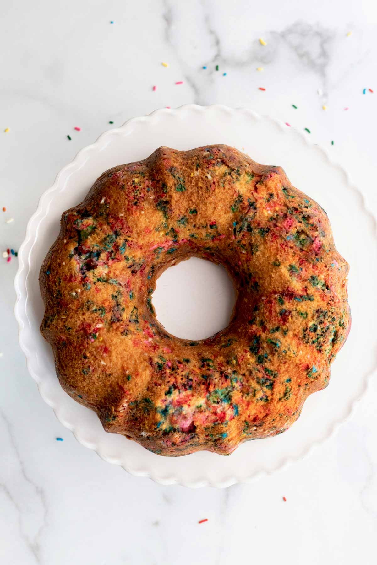A golden brown bundt cake with rainbow sprinkles.