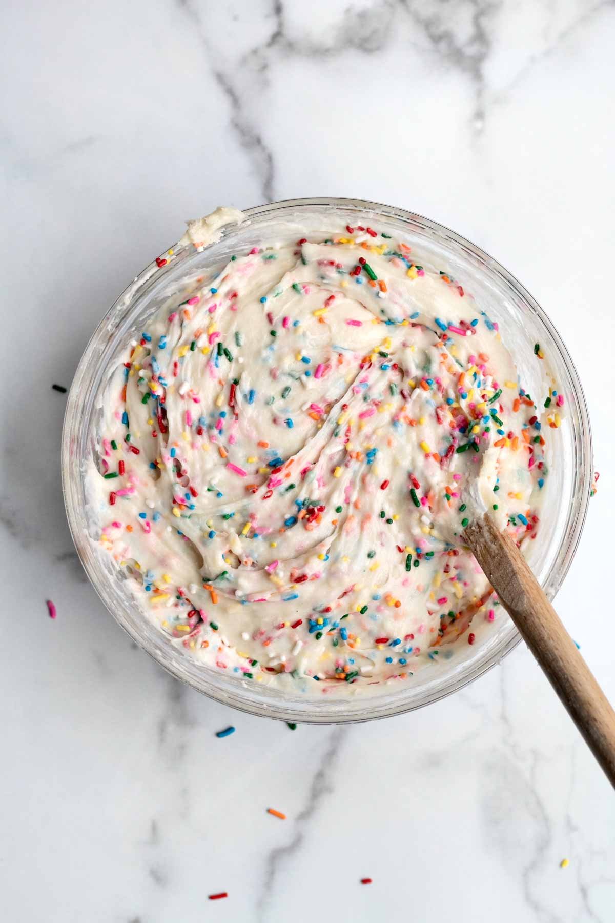 Mixing the rainbow sprinkles thoroughly.