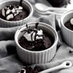 Gluten free Mini Chocolate Cakes in ramekins with whipped cream.