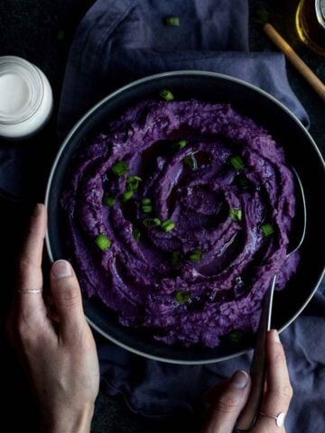A bowl of swirly savory purple mashed potatoes.