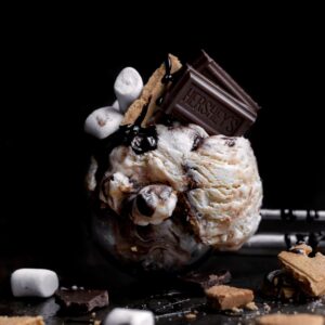 Scoop of S’mores Ice Cream with chocolate bar, crackers and marshmallows.