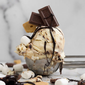 Scoop of delicious gluten-free s’mores ice cream with a Hershey’s chocolate bar, crackers and vegan marshmallows.