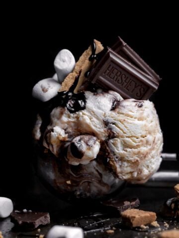 Scoop of S’mores Ice Cream with chocolate bar, crackers and marshmallows.