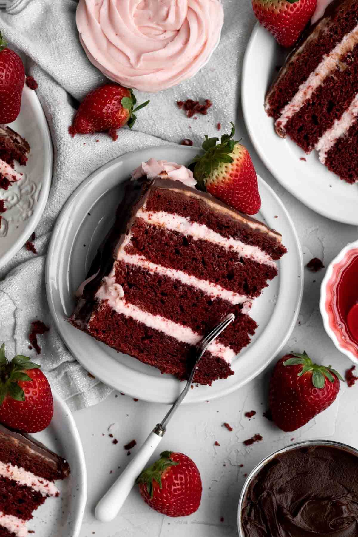 Taking a fork to a slice of red cake.