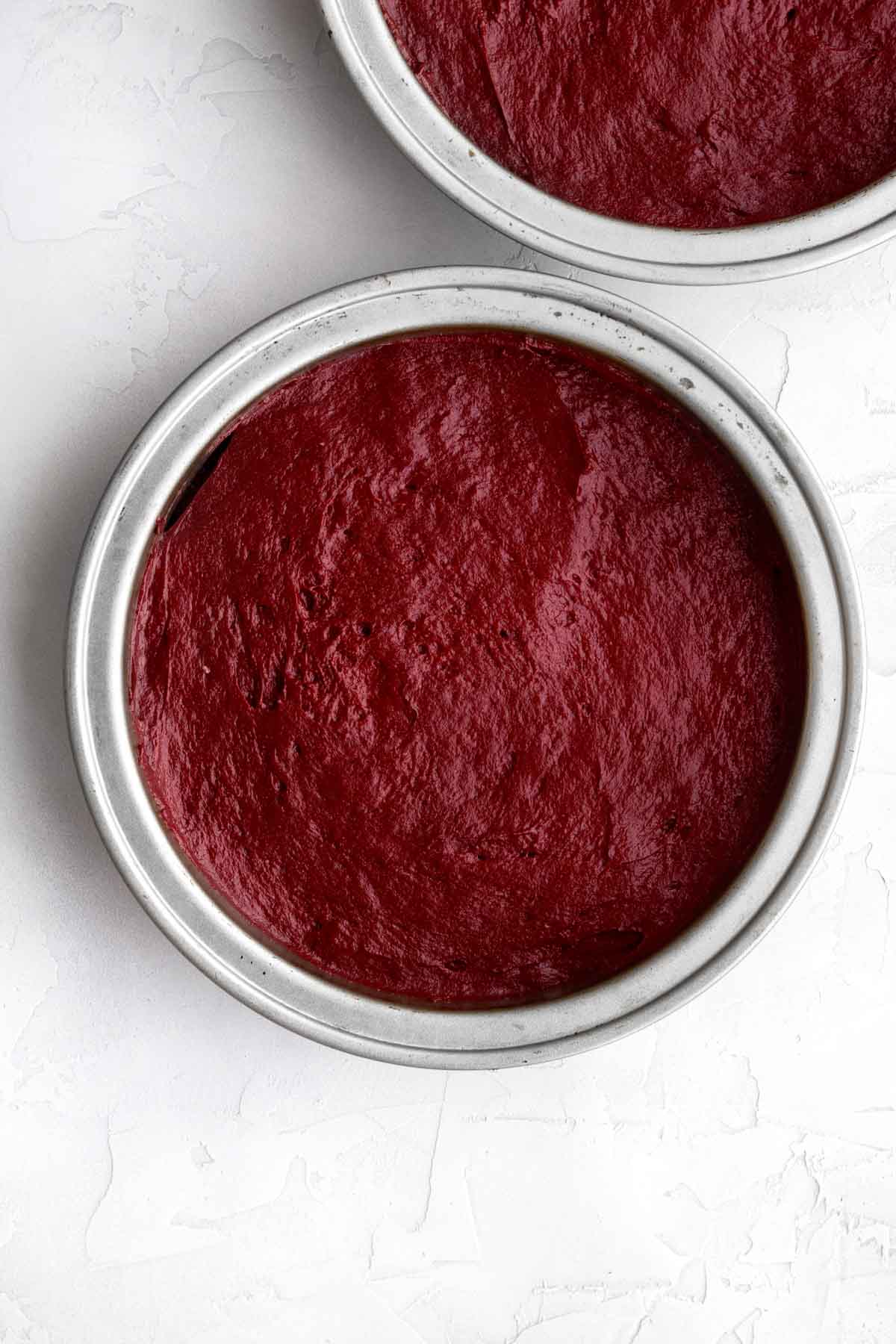 The red batter in circular cake pans.