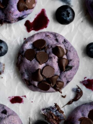 Lavender Blueberry Chocolate Chip Cookie with brown chocolate chips on parchment paper.