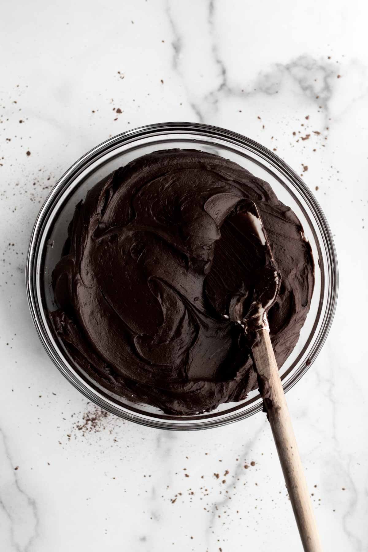 A bowl filled with swirls of chocolate frosting.