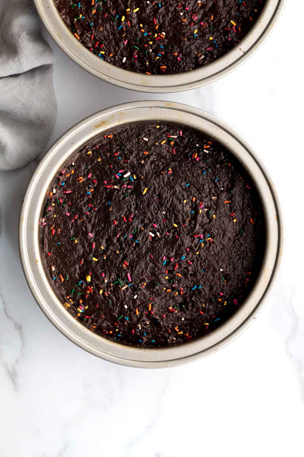 Putting the rainbow dotted batter into a cake pan.