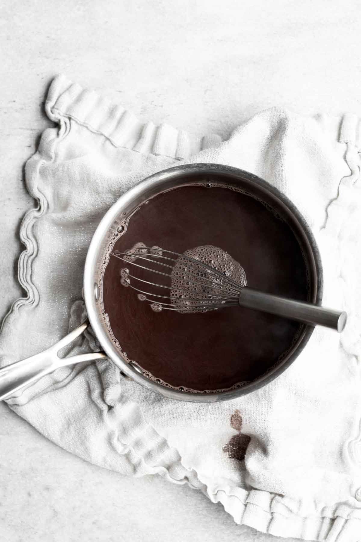 Whisking together water and cocoa powder.