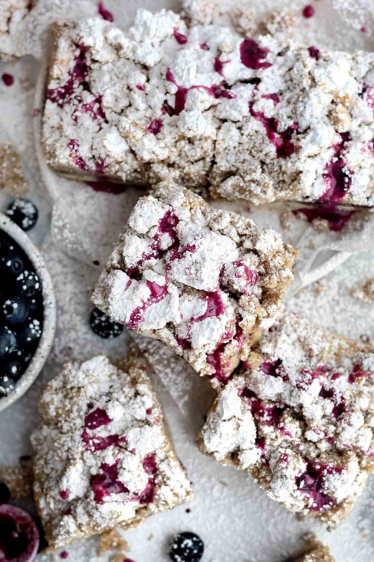 Blueberry glaze is drizzled sporadicly on squares of crumb cakes