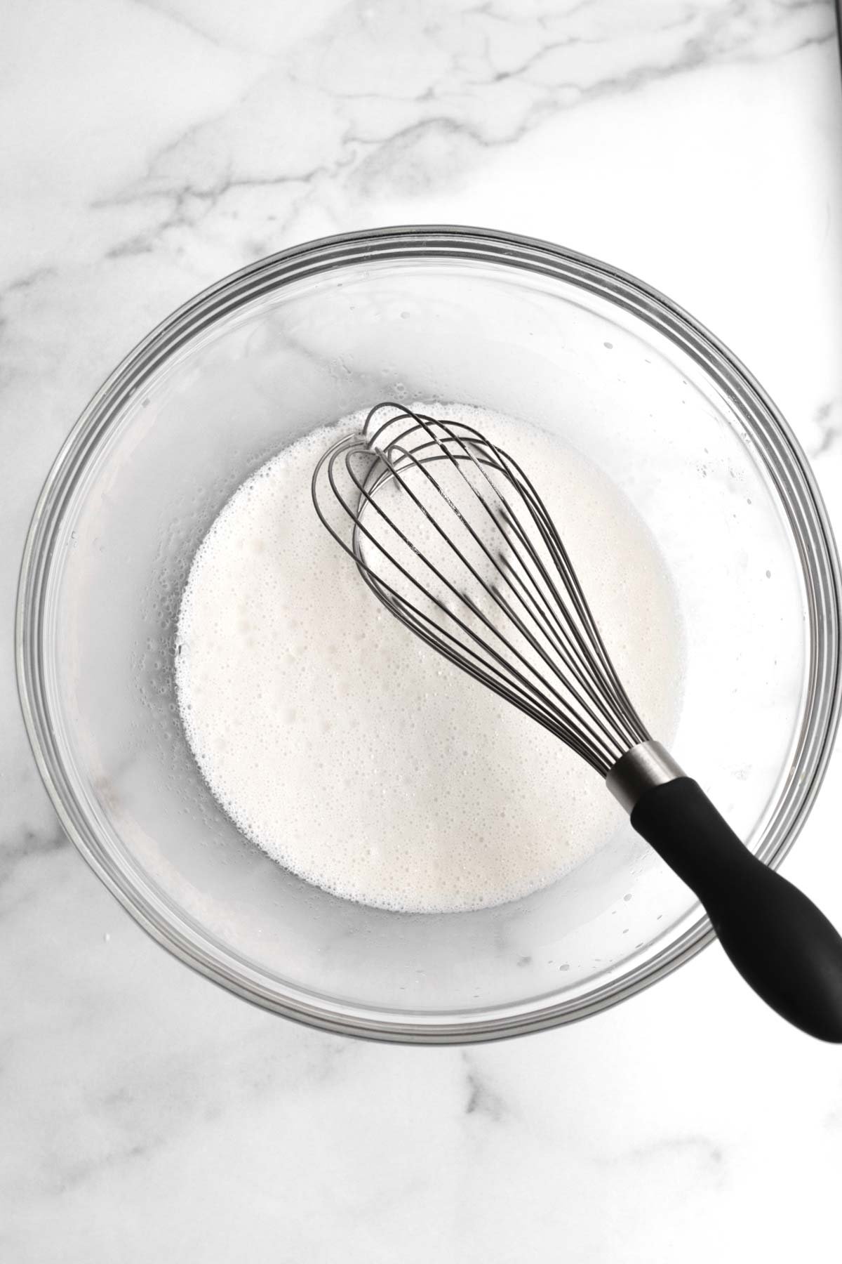 A whisk with the wet ingredients in a bowl.