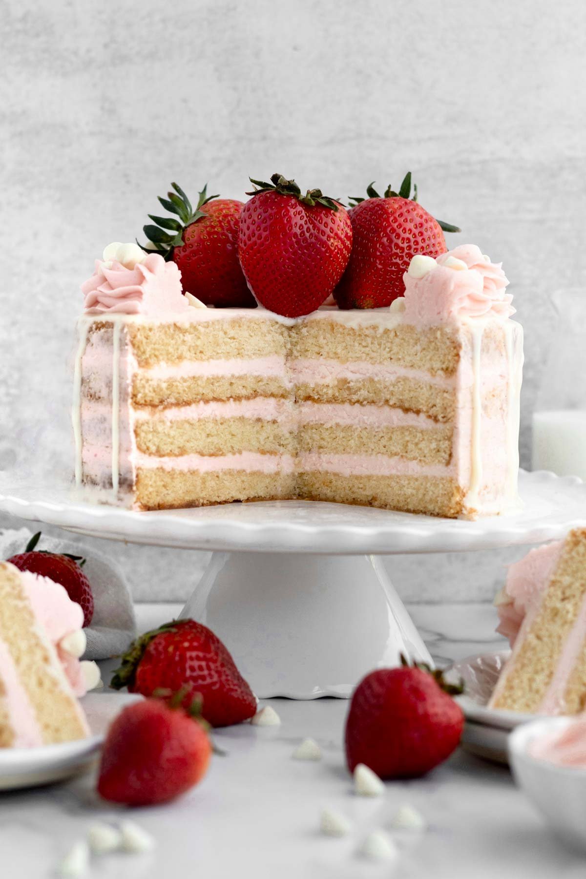 Vanilla Strawberry Cake cut open revealing the layers of frosting and cake.