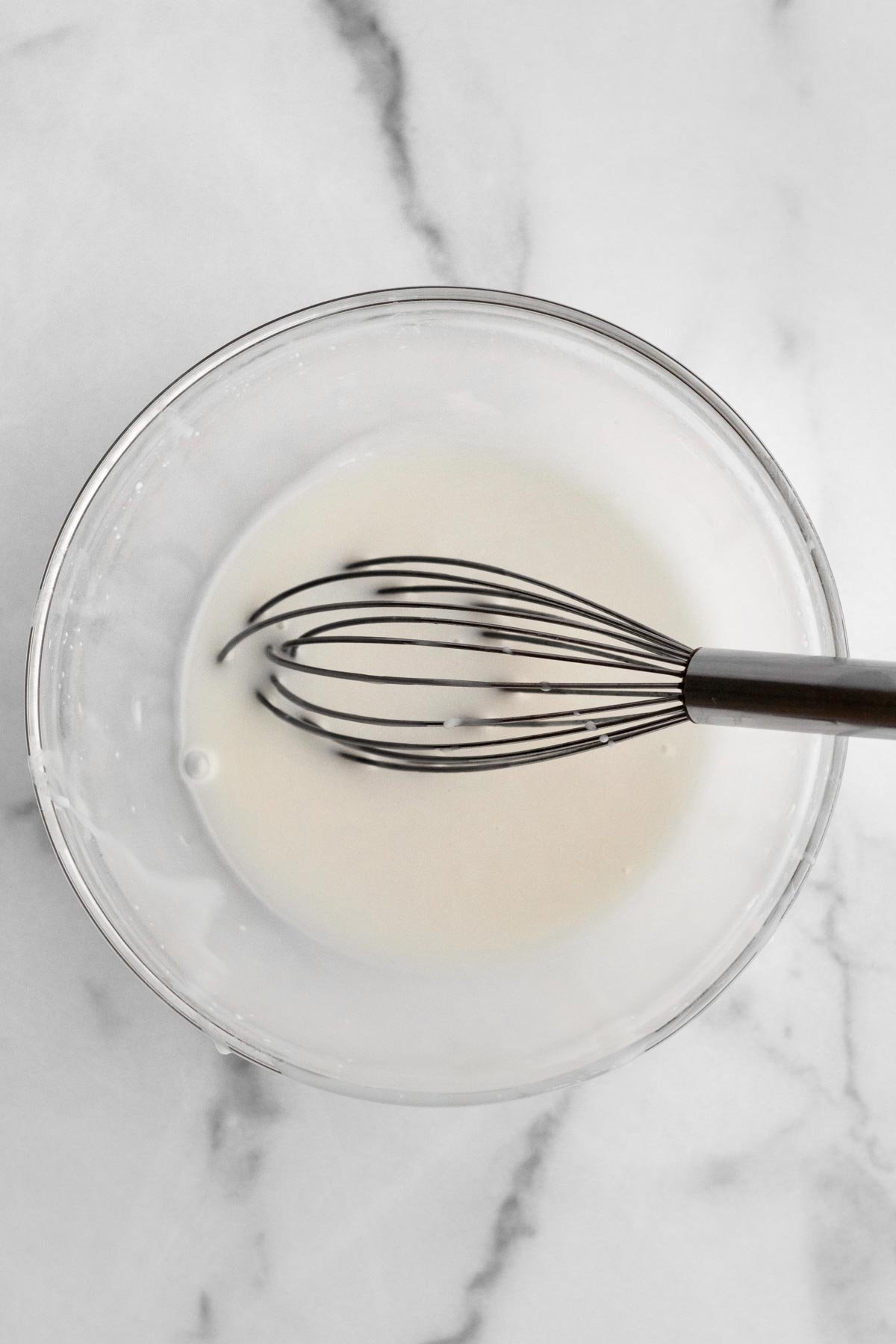 White chocolate drizzle with a whisk.