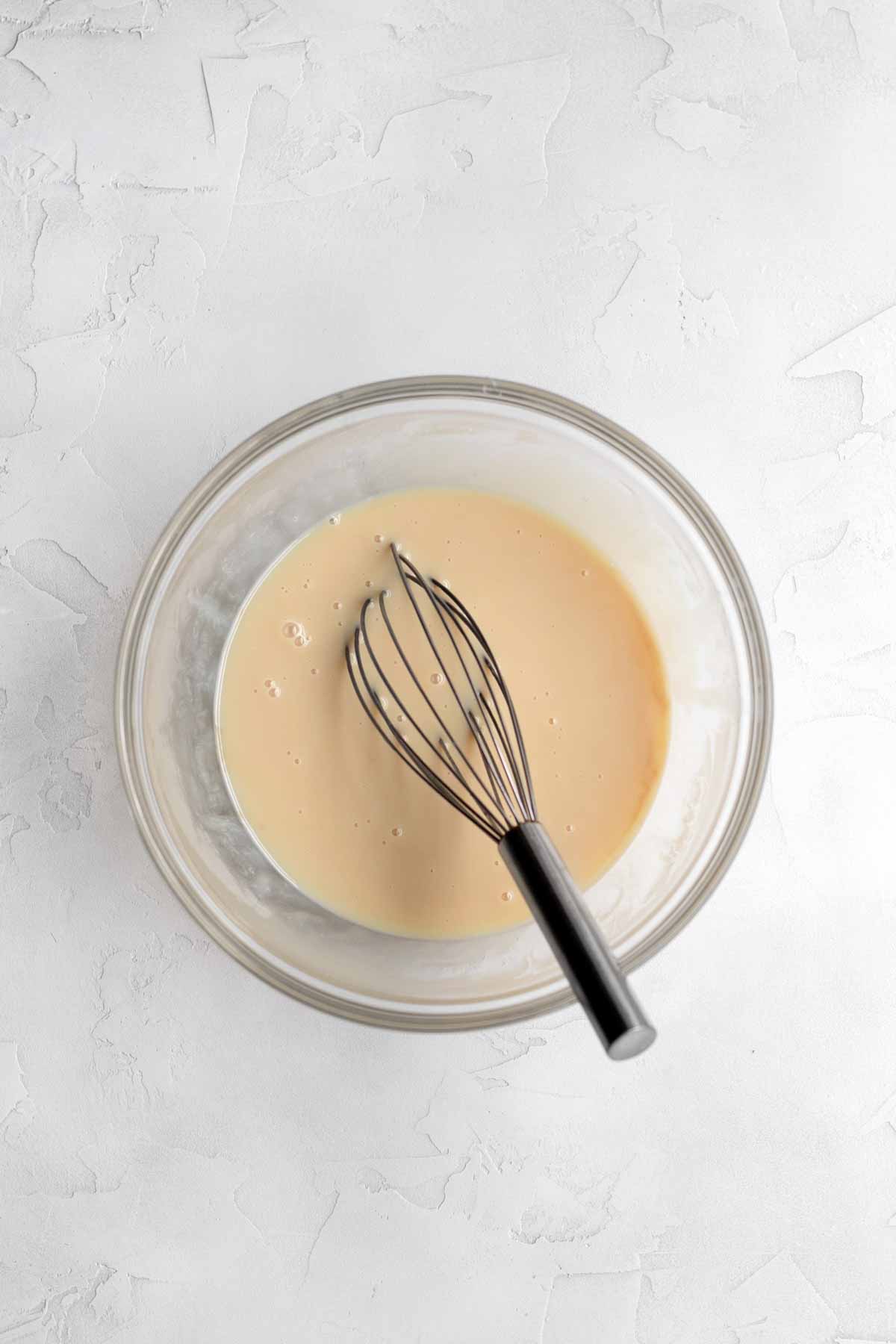 Sweetened condensed milk, vanilla and salt mixed in a bowl.