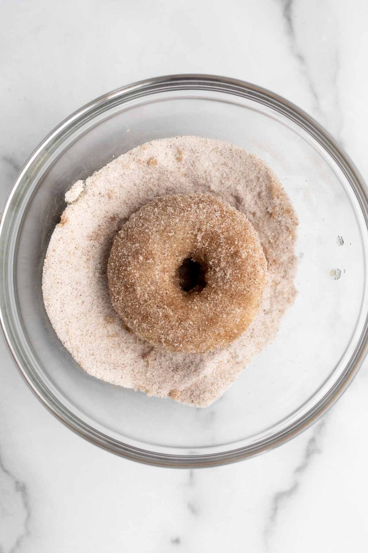 The donut taking a dust bath in the cinnamon sugar.