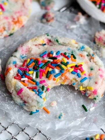 A Sprinkle Sugar Cookie with a bite taken out.