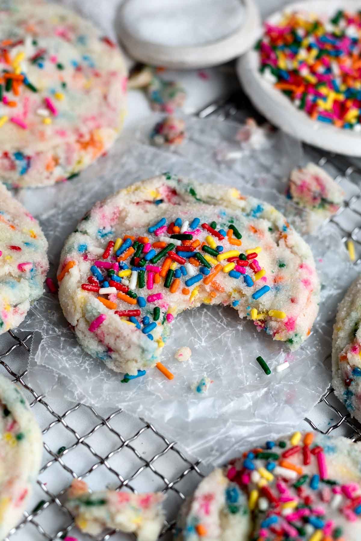 A Sprinkle Sugar Cookie with a bite taken out.