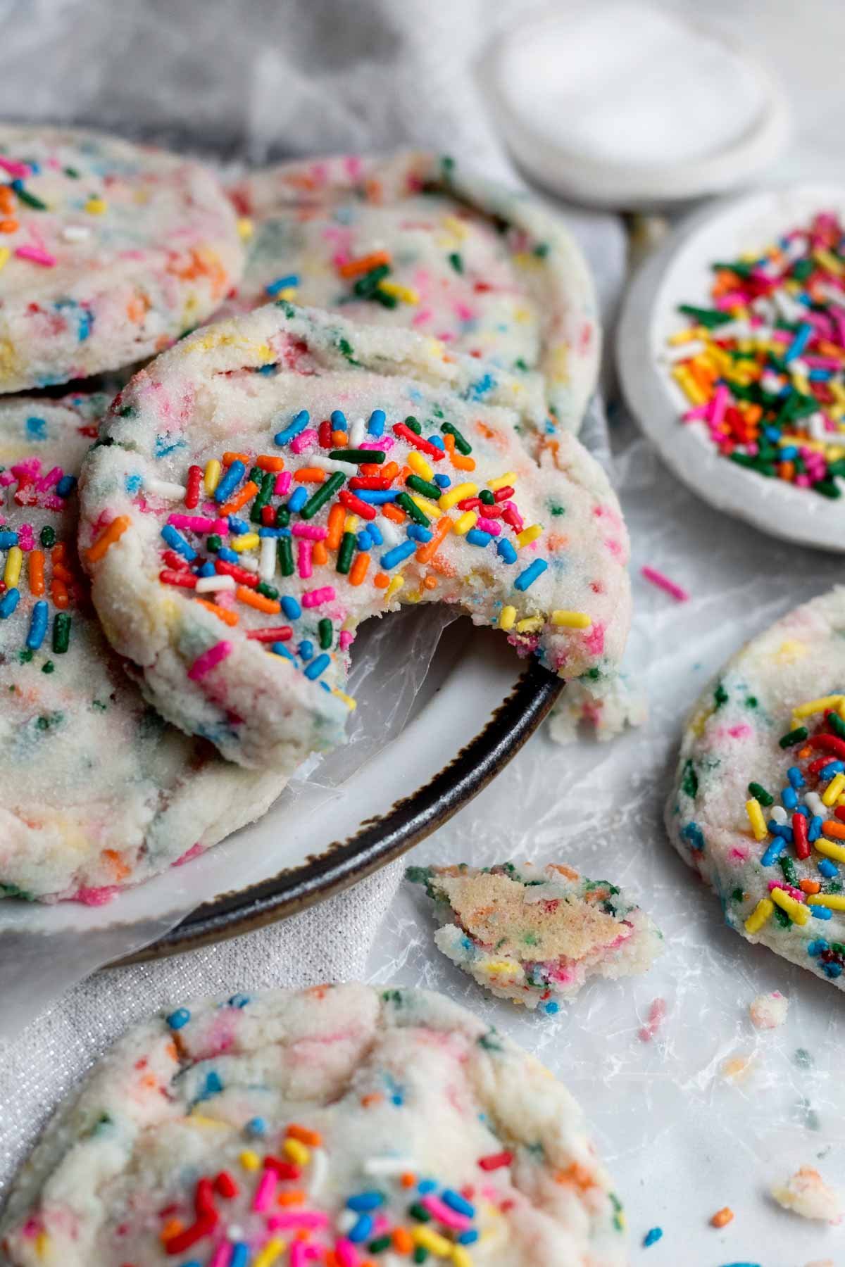 A plate of cookies with rainbow sprinkles and sugar.