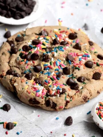 A giant Happy Birthday Cookie with rainbow sprinkles and chocolate chips.