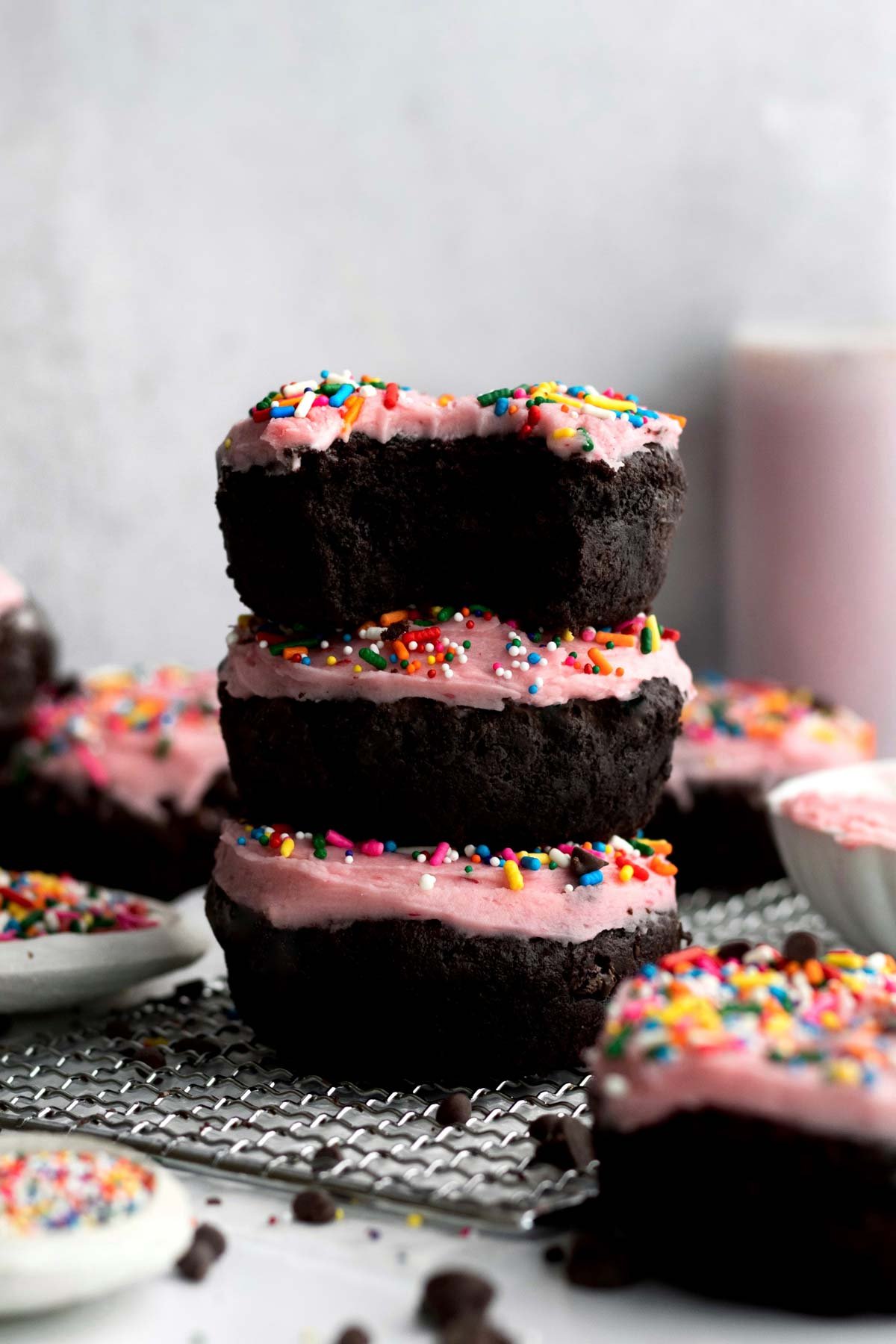 A stack of three Happy Birthday Donuts with raspberry frosting and sprinkles.