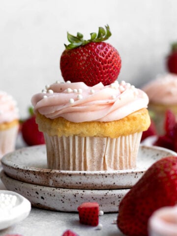 Pink frosted Strawberry Filled Cupcake with white dot sprinkles.