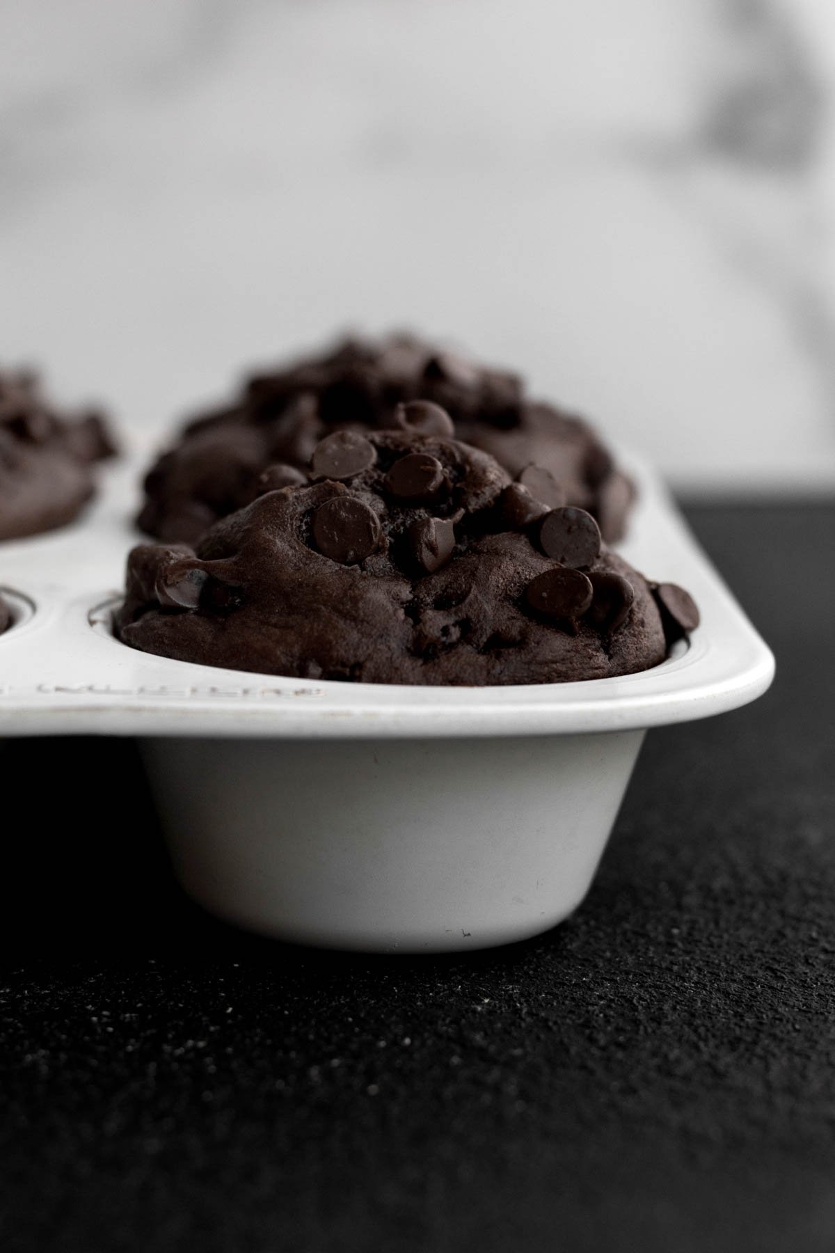 Chocolate muffins in a muffin tray.