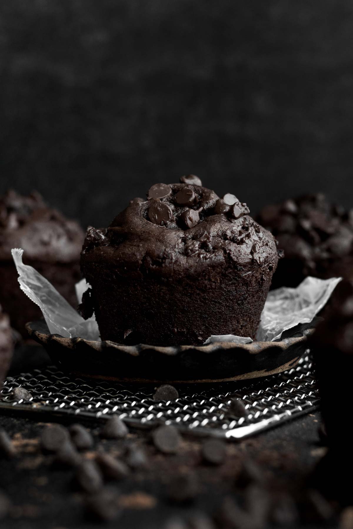 A proud chocolate muffin standing in the darkness.