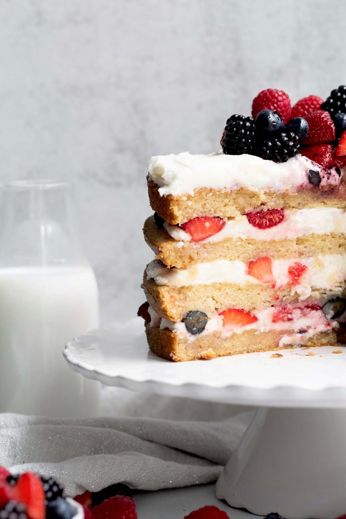 Alternating slices of golden cake and vanilla frosting infused with mixed berries.