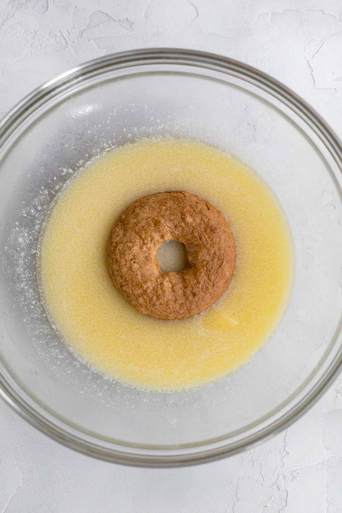 The plain donut in a bowl with melted butter.