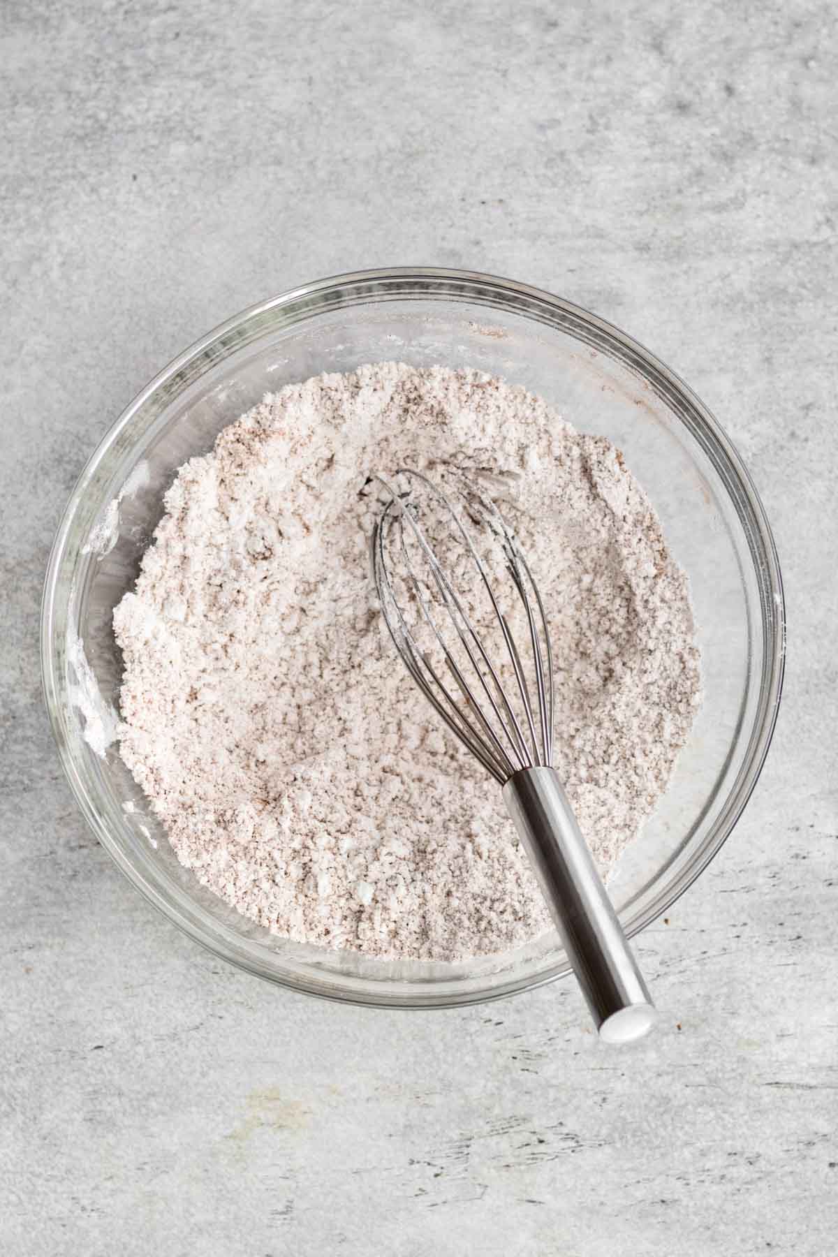 A whisk with flour and cinnamon sugar.