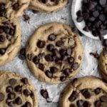 Cookies with chocolate chips on wax paper.
