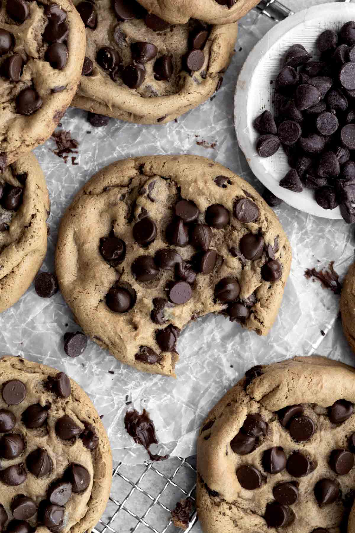 Looking down on chocolate chip cookies, one with a bite.