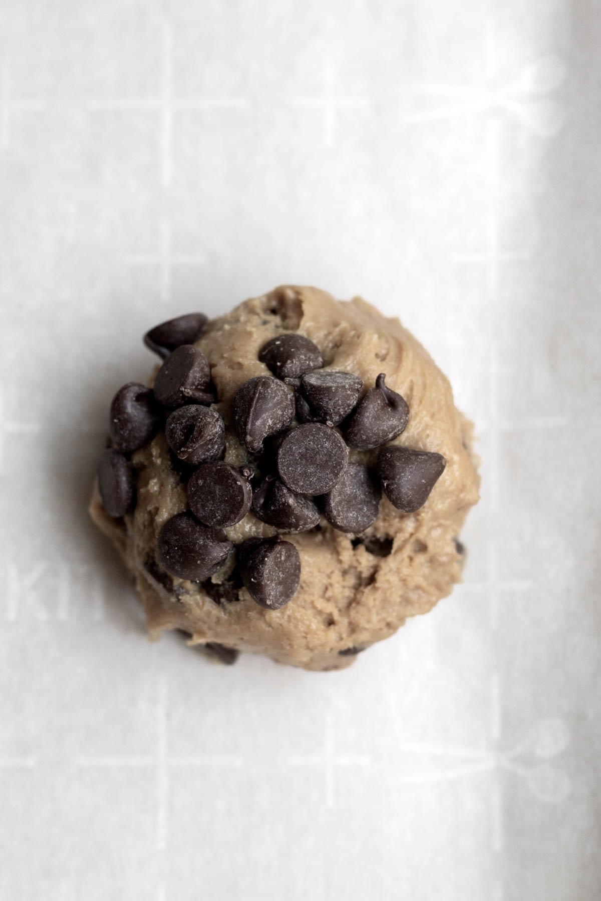 Cookie dough ball covered in chocolate chips.