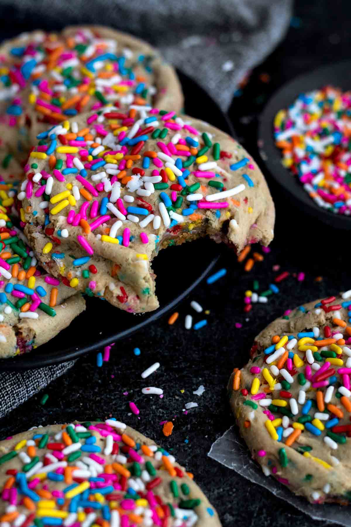 An overflowing plate of bright rainbow sprinkled Funfetti Cookies ready to be enjoyed.