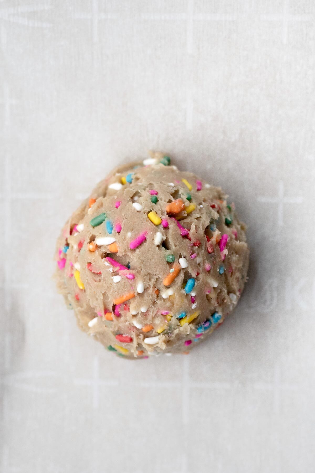 A ball of rainbow sprinkle infused dough.