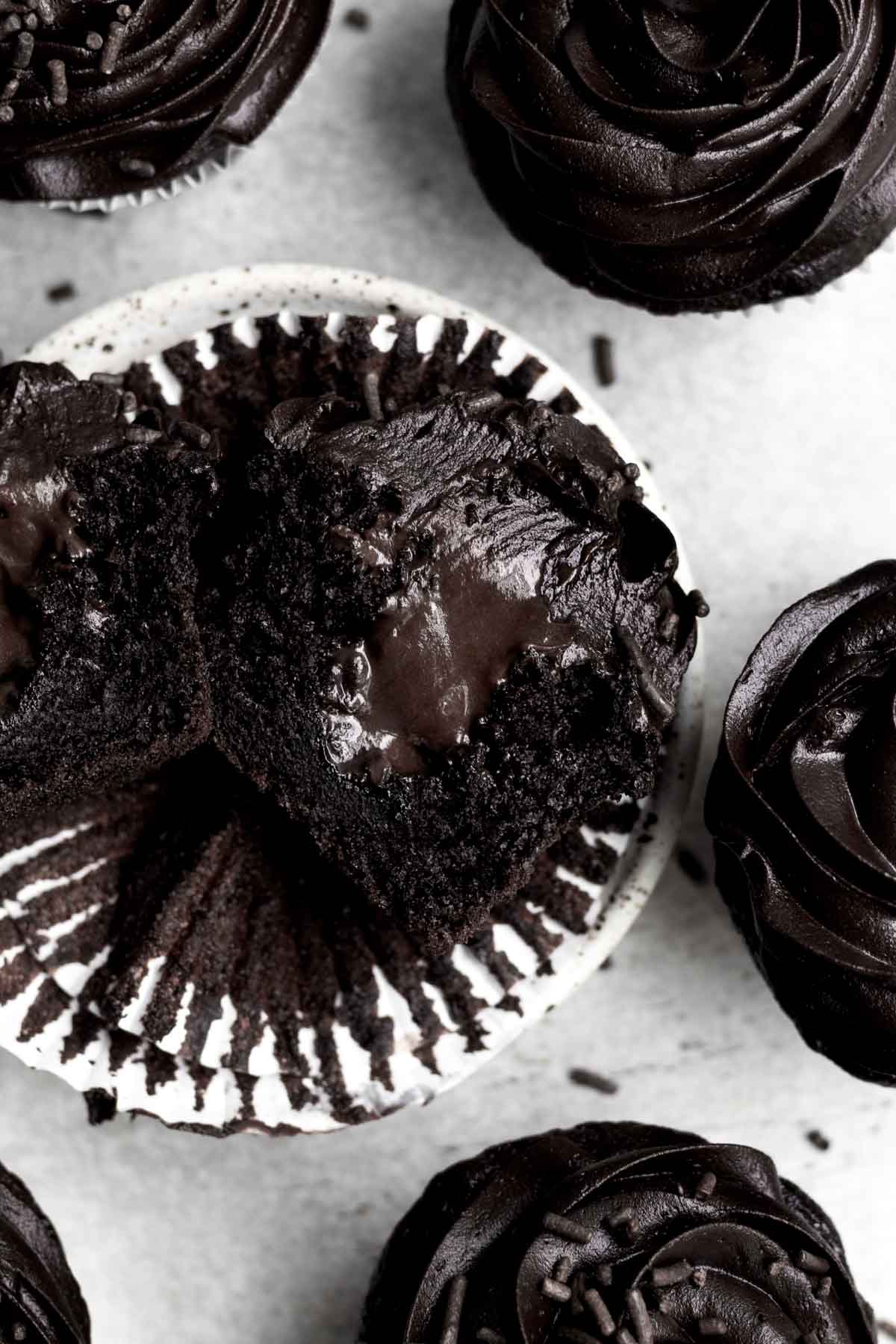 A sliced cupcake with chocolate ganache filling.