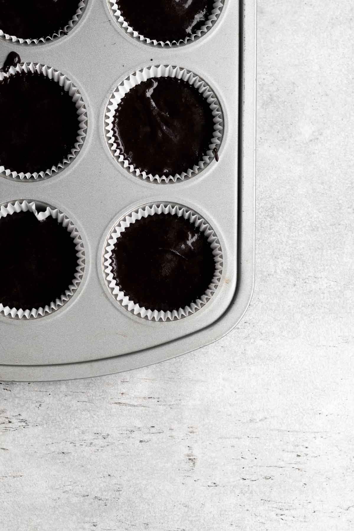 Cupcake tin filled with chocolate batter.