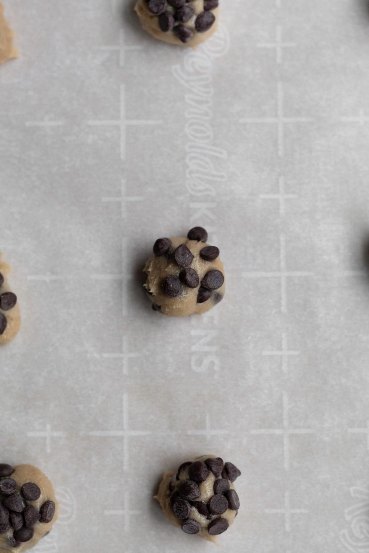 Adding extra chocolate chips to the dough balls.