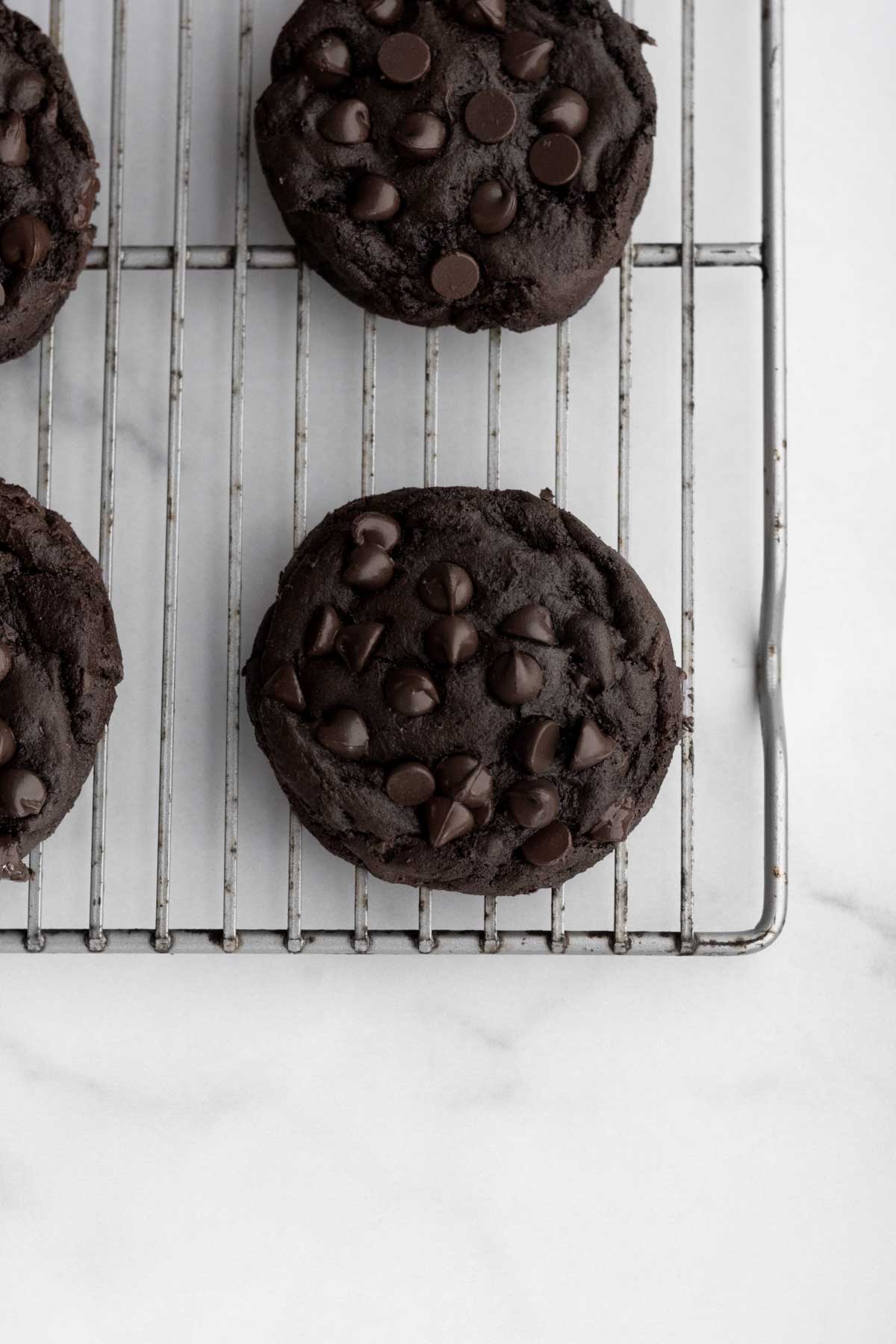 Warm and soft baked Dark Chocolate Chip Cookies on a cooling rack.