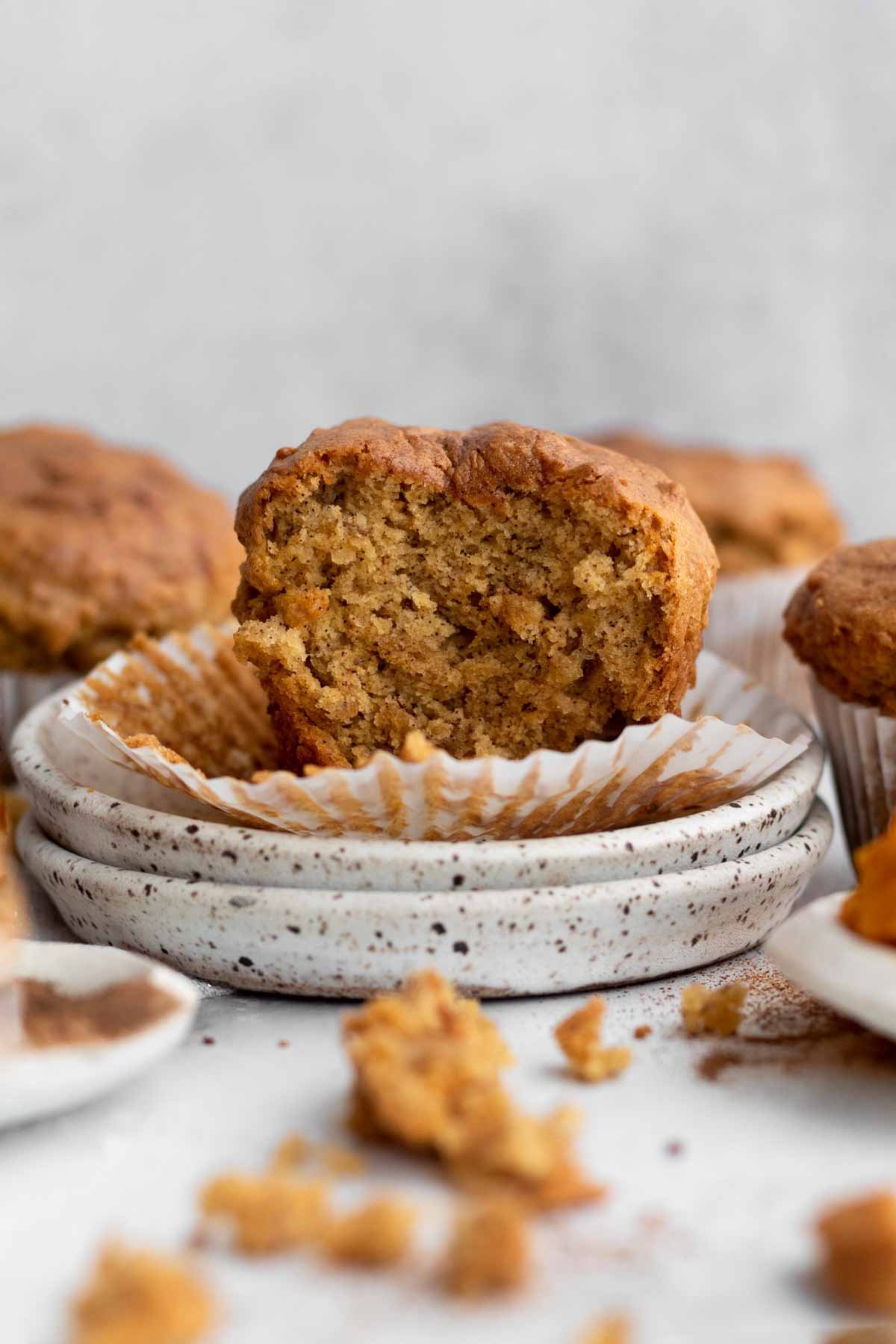 A delicious muffin stands proudly on a plate with a bite taken out.