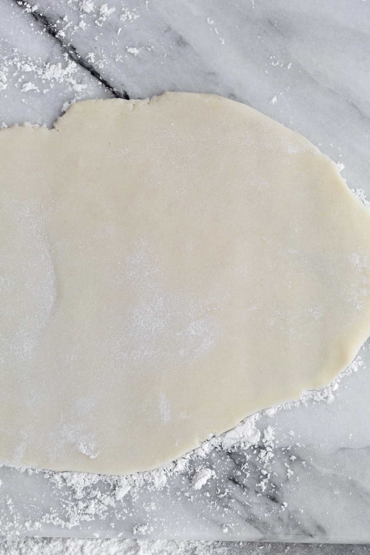 Rolling the dough out into a sheet.